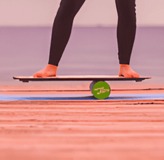 uma pessoa se equilibrando em uma prancha e um objeto cilindrico de pilates